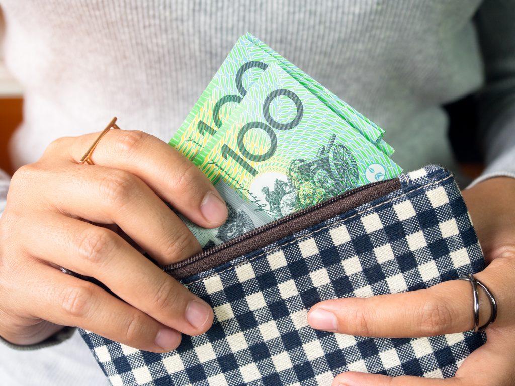 Girl put dollar australia money in pocket.